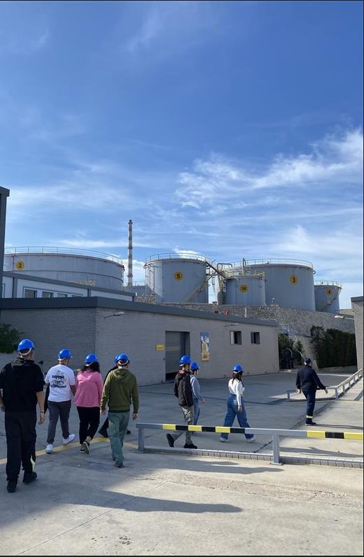 A group of people walking in front of a factory AI-generated content may be incorrect.